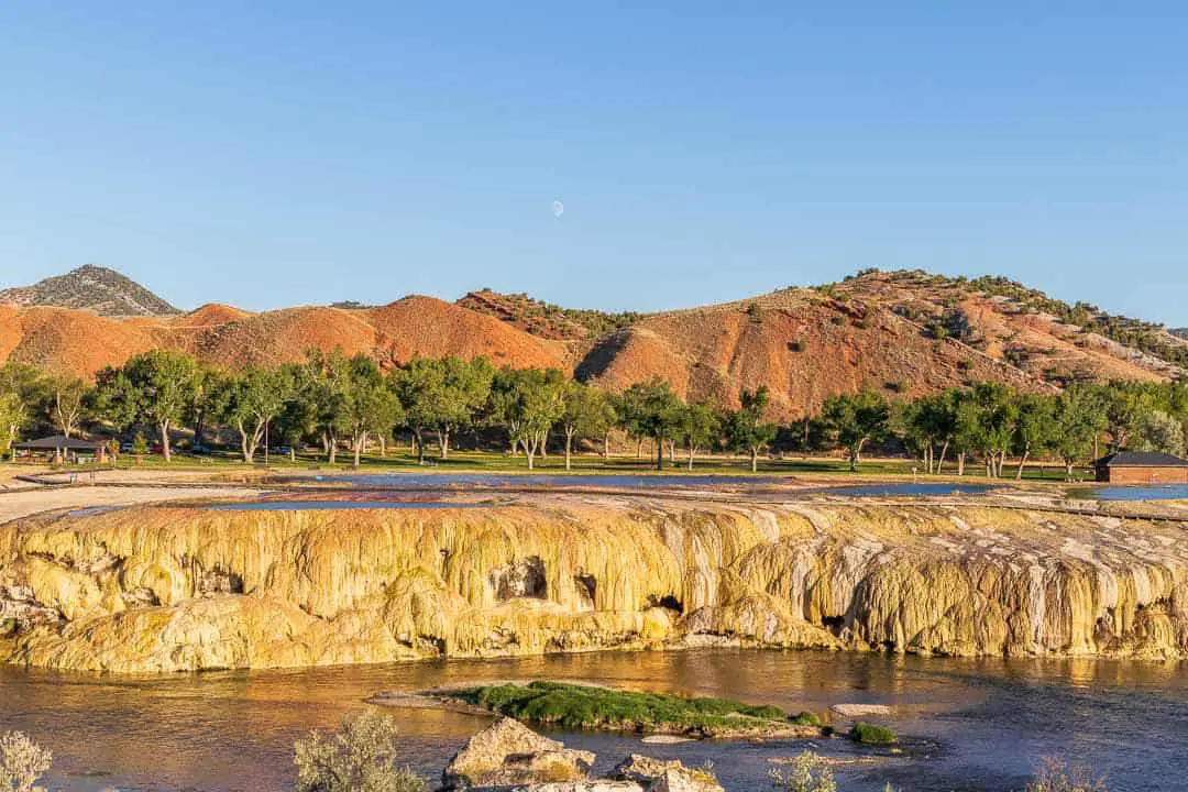 Landscape view of Mineral hot springs waterfall formation with large hills in the background