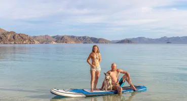 Couple with dog on a paddleboard in the ocean
