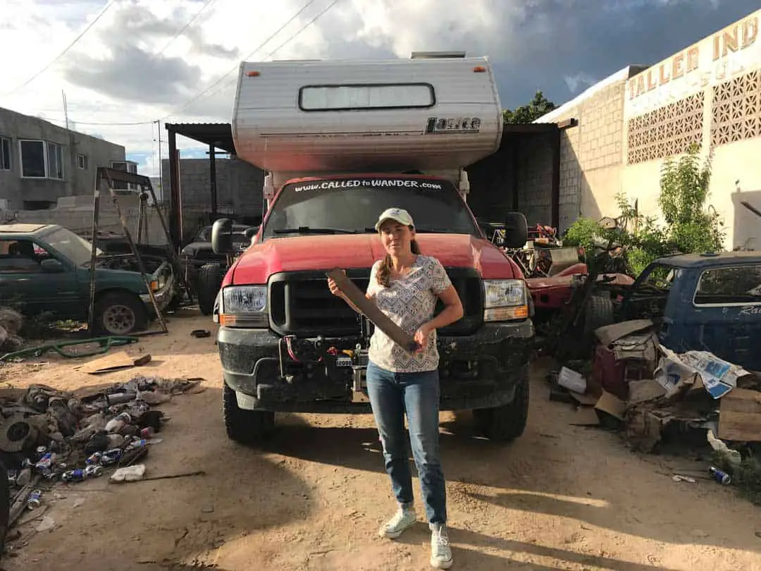 Woman holding a broken part in a mechanic shop