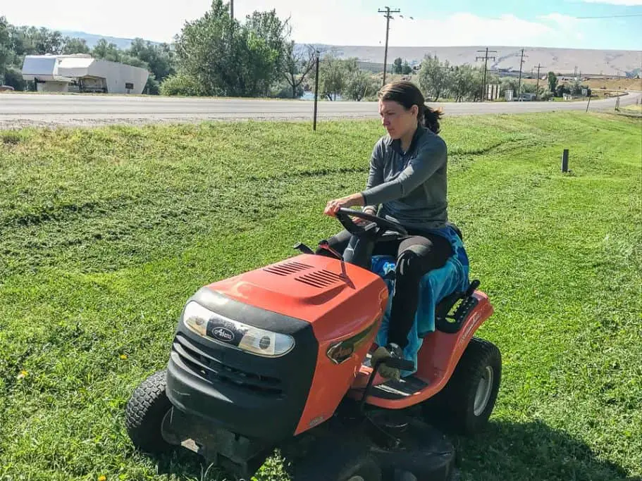 Lindsay riding a lawnmower while work camping