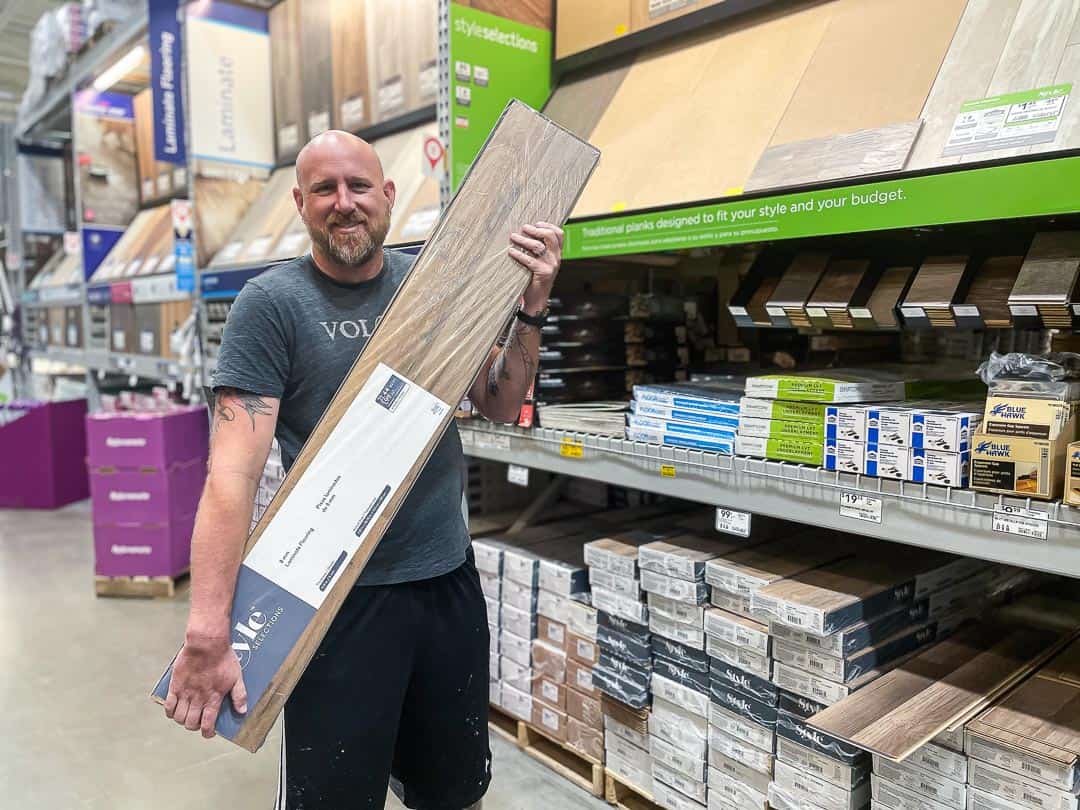 Man holding a case of wood flooring