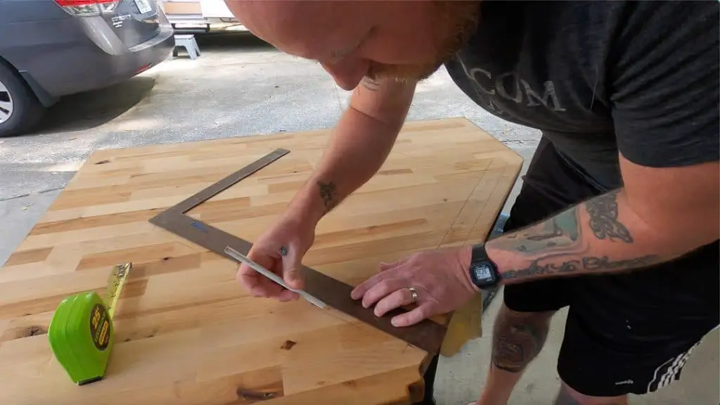 Man Measuring the hole to cut out for the new sink in the butcher block counter