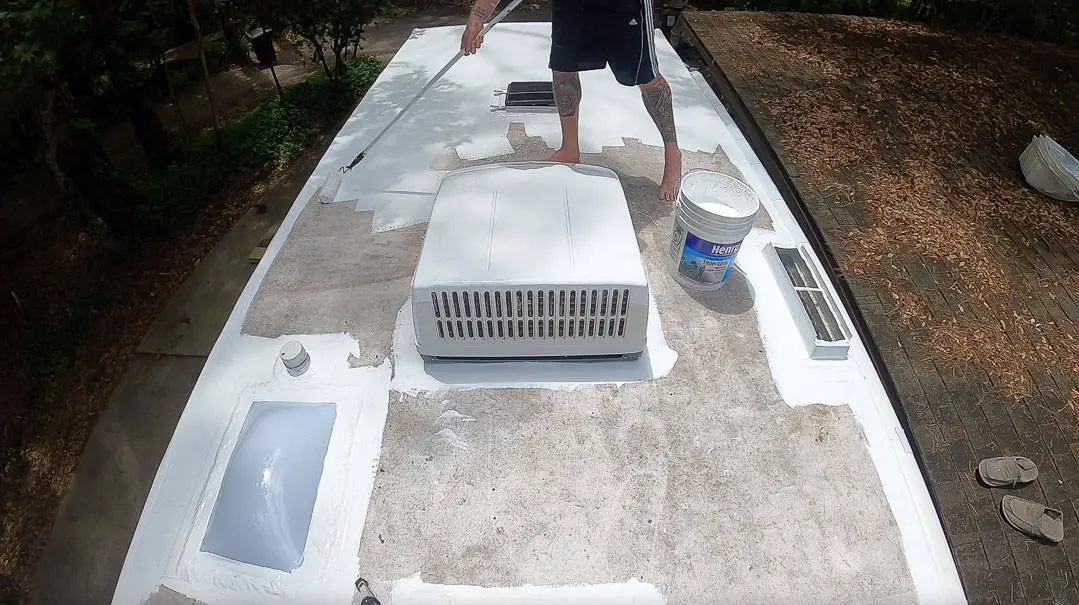 Man painting/coating an RV roof with Henry's tropicool