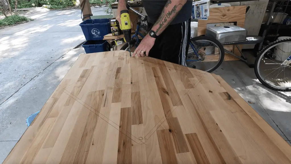 Man drilling a hole into the new butcher block counter