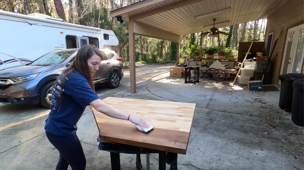 Woman staining the new butcher block counter dark brown