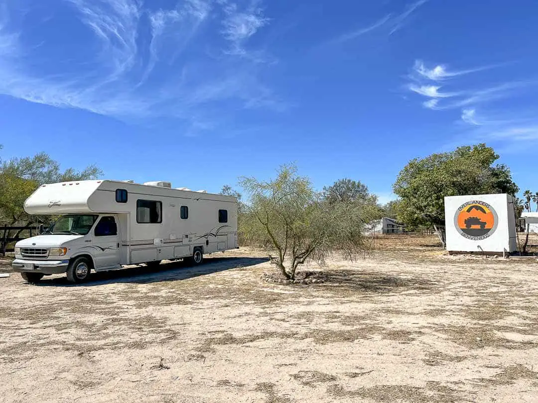 RV parked in a sandy area at a ranch