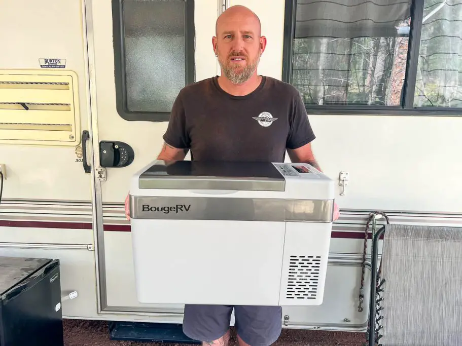 Man holding a portable chest style fridge/freezer